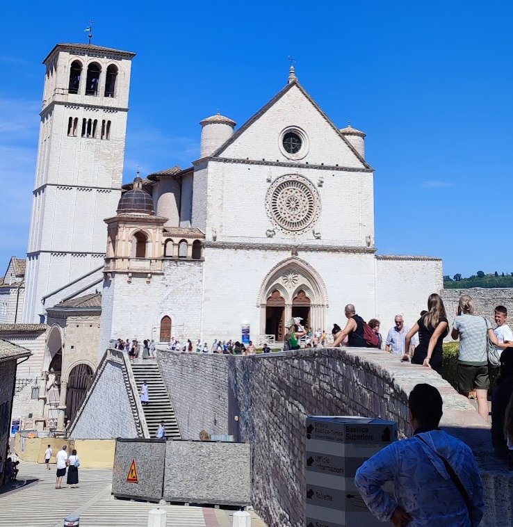 Pilgrims and visitors below the facade of the Basilica of San Francesco in Assisi