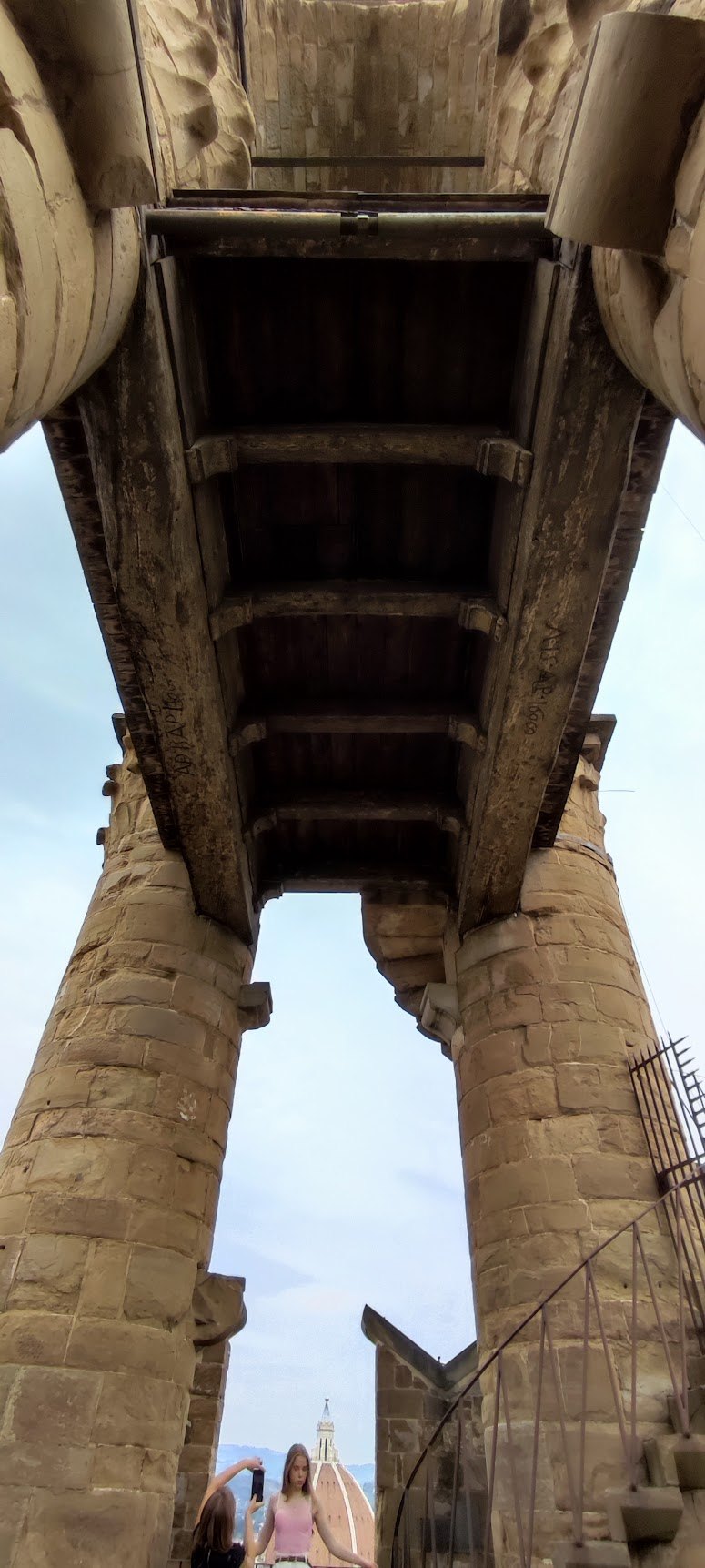 Stone corbels and timber decking supporting the projecting walkway of the Arnolfo Tower