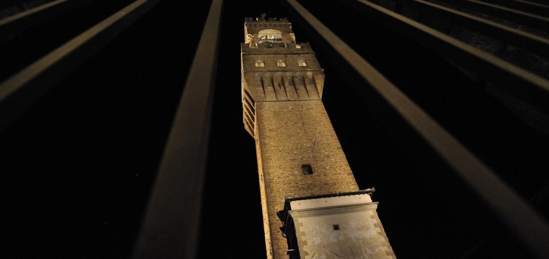 The Arnolfo Tower of Palazzo Vecchio lit at night in Florence