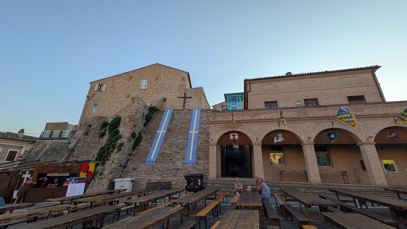 Banners and painted coats of arms on the castle walls above Piazza Alta Castello in Grottazzolina, Marche