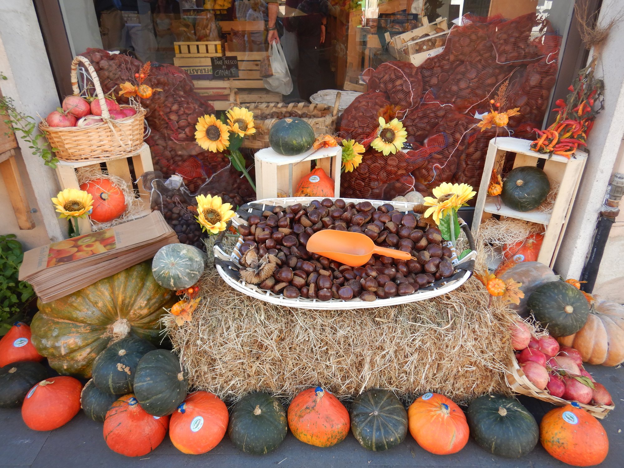 Fresh chestnuts, pumpkins, and autumn produce at an Italian market stall in October
