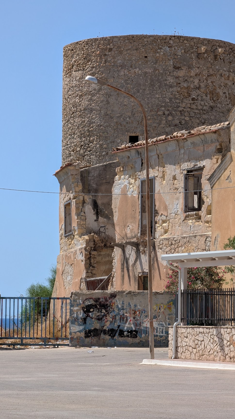 Roofless twentieth-century building attached to Torre di Gaffe, with spray-painted walls and missing plaster