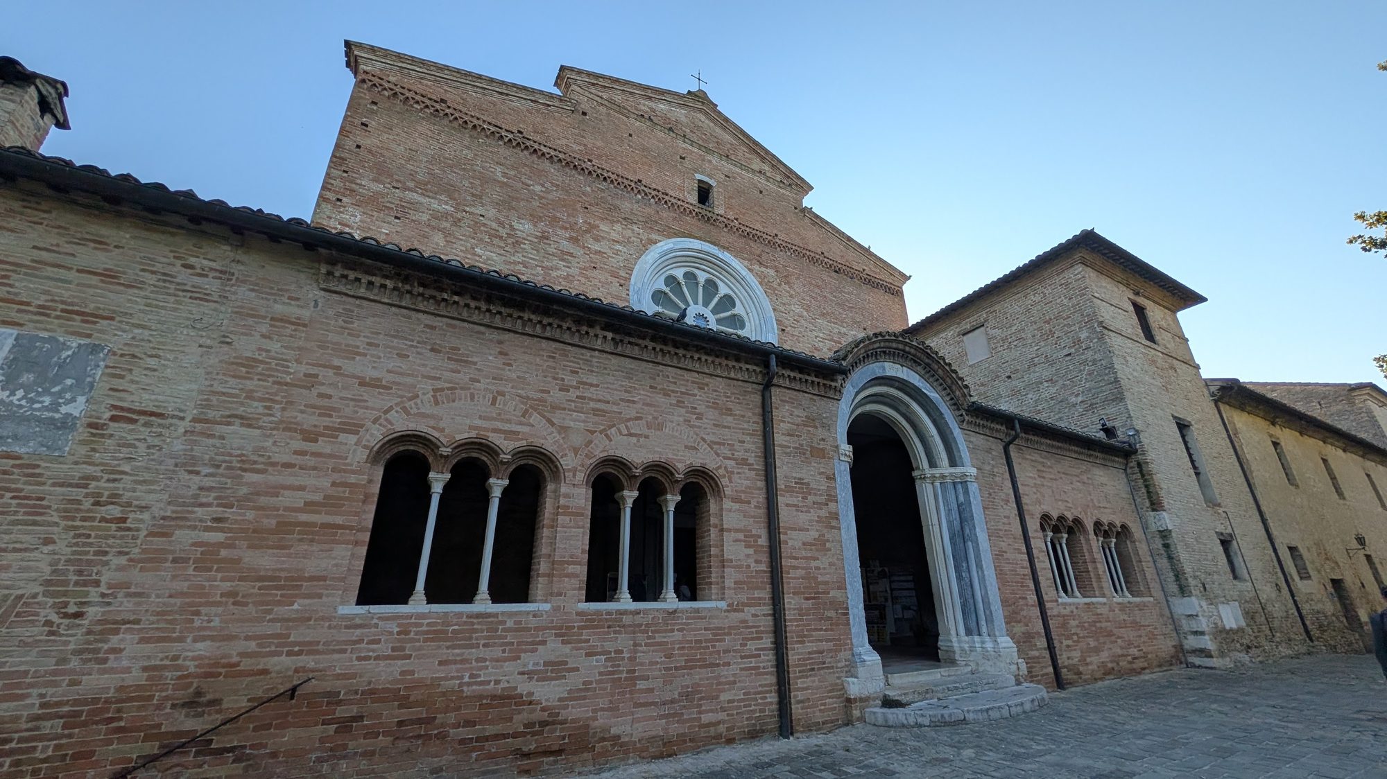 Brick facade and rose window of the Abbazia di Fiastra, a Cistercian abbey in the Marche, Italy