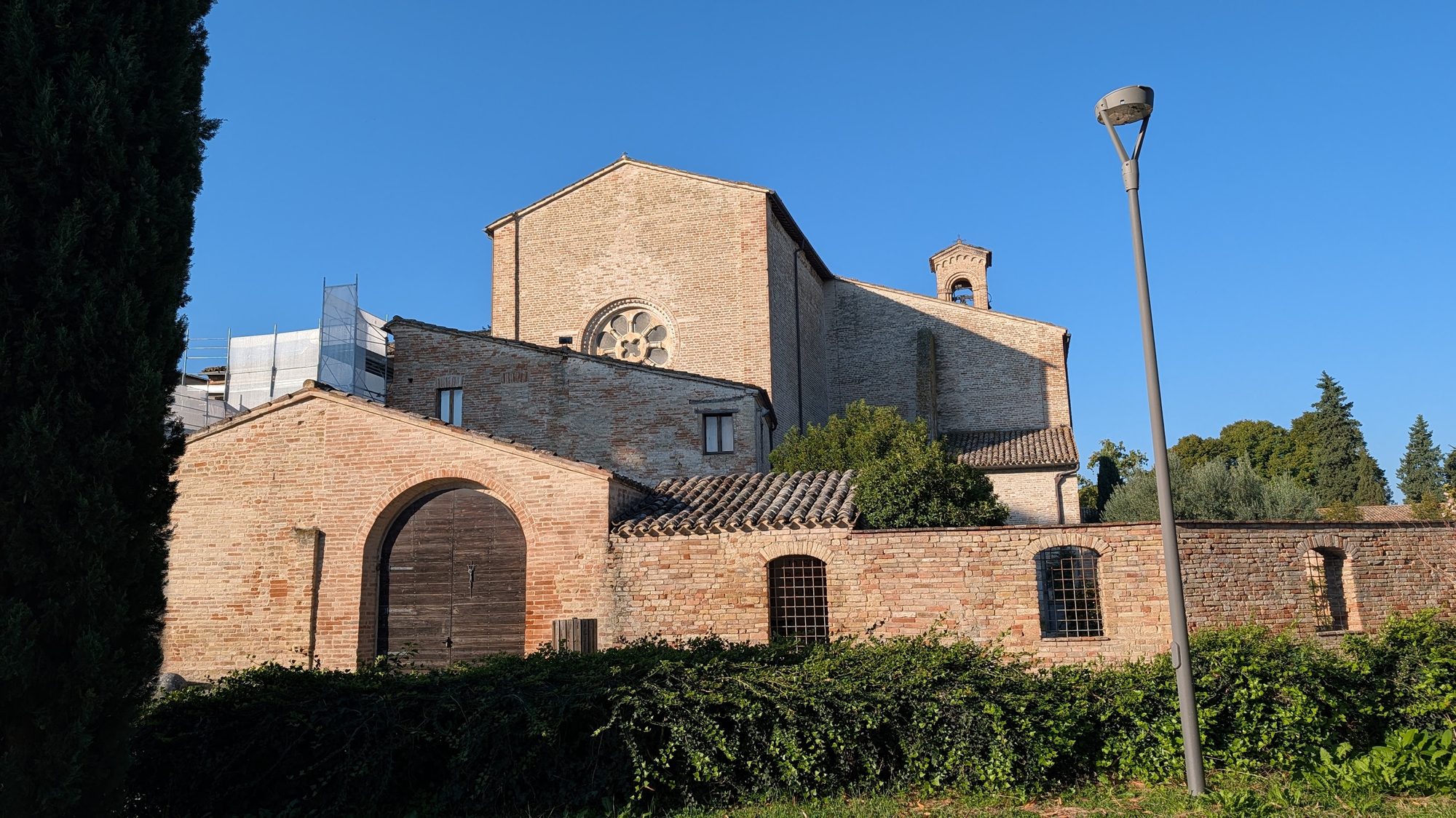 Exterior of the Abbazia di Fiastra with scaffolding from ongoing restoration work
